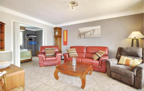 a living room with red leather furniture and a table at Beautiful Home In Saint-André in Saint-André
