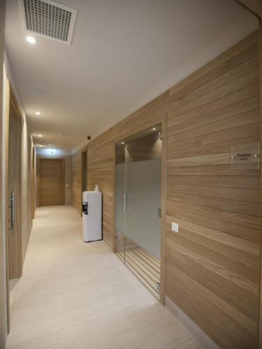 a hallway with wooden walls and a refrigerator at Parkhotel Delta, Wellbeing Resort in Ascona