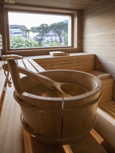 a wooden tub in a room with a window at Parkhotel Delta, Wellbeing Resort in Ascona