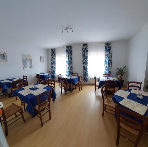 Picobello Pension في غورليتز: غرفة طعام مع طاولات وكراسي زرقاء