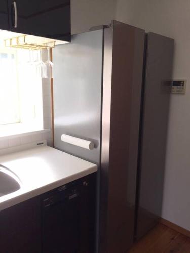 a kitchen with a stainless steel refrigerator and a sink at 貸別荘Casa de Campo 2SLDK别墅 駐車場 芝生東屋付き BBQ 大室山と海遠望伊豆高原5分 in Ito