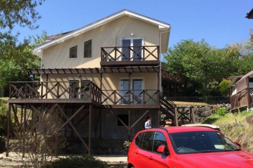 a house with a red car parked in front of it at 貸別荘Casa de Campo 2SLDK别墅 駐車場 芝生東屋付き BBQ 大室山と海遠望伊豆高原5分 in Ito
