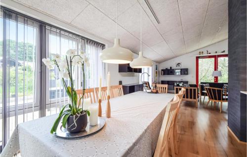 a kitchen and living room with a large table with flowers on it at 3 Bedroom Beautiful Home In Fårvang in Fårvang