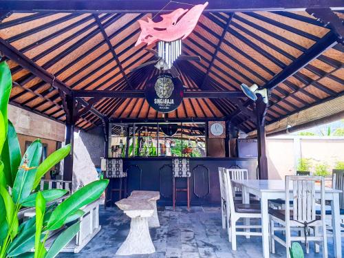a patio with a table and chairs and a bar at Kubuku Eco Dive Lodge and Yoga in Pemuteran