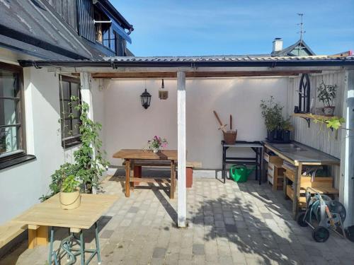 een patio met een tafel en banken bij Fishermans Cottage Anno 1861 - Skåre Fiskeläge in Trelleborg