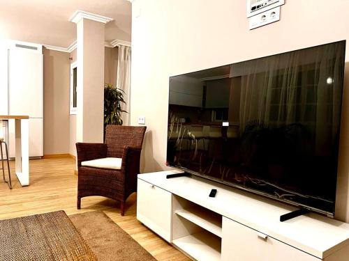 sala de estar con TV de pantalla plana grande en ÁTICO RIBEIRA CENTRO, en Ribeira
