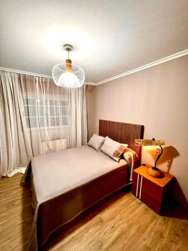 a bedroom with a bed and a lamp and a window at ÁTICO RIBEIRA CENTRO in Ribeira