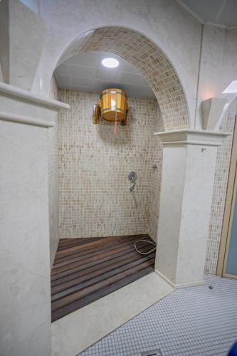 a bathroom with a shower with a light on the wall at Badam d'Art Boutique Hotel in Baku