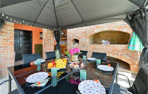 a table with plates of food on it under a tent at Lovely Home In Kapela in Kapela