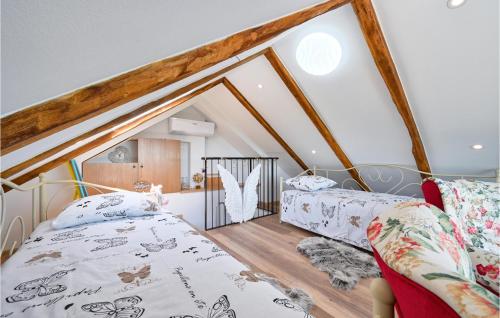 a attic bedroom with two beds and a loft at Lovely Home In Kapela in Kapela