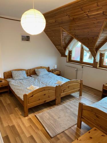 sypialnia z dużym drewnianym łóżkiem w pokoju w obiekcie Global Apartmanház w mieście Vonyarcvashegy