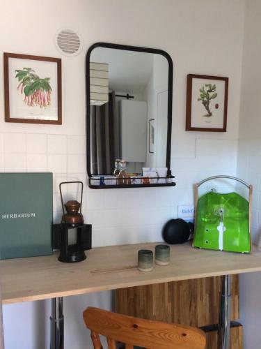 un comptoir avec un miroir et un sac vert dessus dans l'établissement Nuitée Naturopathique, à La Rochelle
