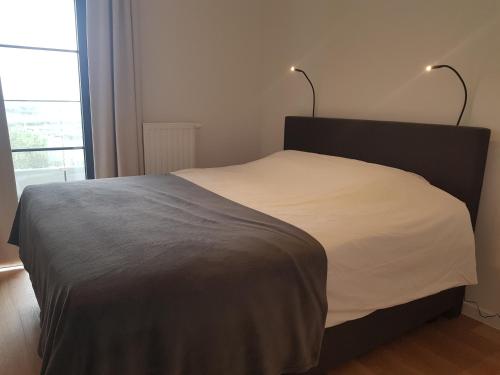 ein Schlafzimmer mit einem Bett mit zwei Lampen darüber in der Unterkunft The One - New luxury beachfront apartment in Blankenberge