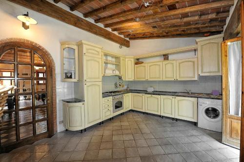 a kitchen with white cabinets and a washer and dryer at Mancino in Poggibonsi
