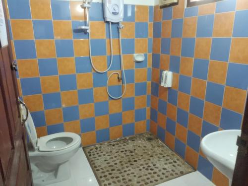 a bathroom with a toilet and a shower at Sainamhai Resort in Ban Namsanam