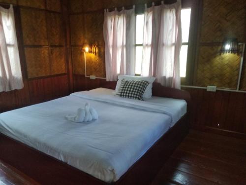 a bedroom with a bed with two white towels on it at Sainamhai Resort in Ban Namsanam