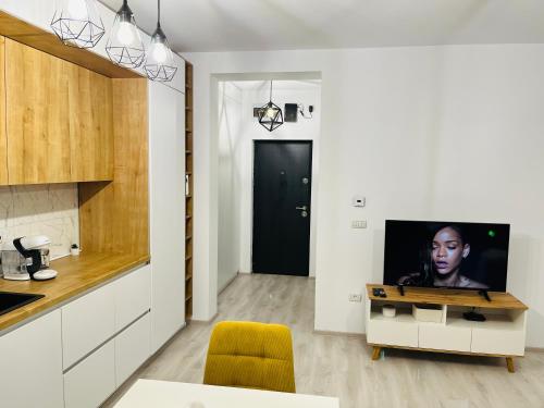 a living room with a tv and a kitchen at Apartament 1 camera Giroc in Giroc