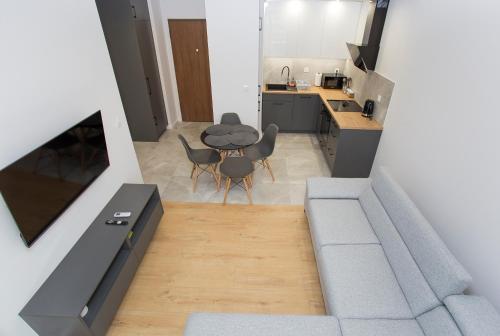 a kitchen and dining room with a table and chairs at Urban Jungle Apartament Felicia in Białystok