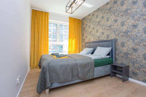 1 dormitorio con 1 cama con cortinas amarillas en Urban Jungle Apartament Felicia en Białystok