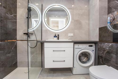 La salle de bains est pourvue d'un lave-linge et d'un lavabo. dans l'établissement Urban Jungle Apartament Felicia, à Białystok