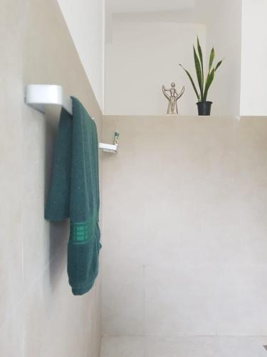 a green towel hanging on a wall in a bathroom at Pearl's Homestay Matale in Matale
