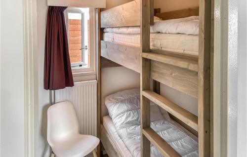 a small room with bunk beds and a white chair at 2 Bedroom Lovely Home In Heinkenszand in Heinkensand