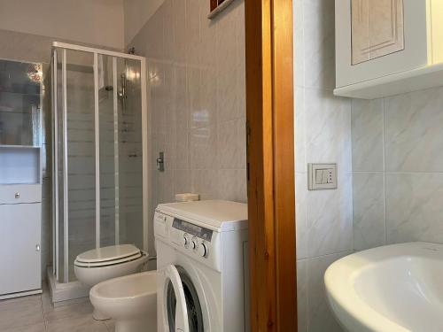 uma casa de banho com uma máquina de lavar roupa e um WC em La Perla nel Blu em Villasimius