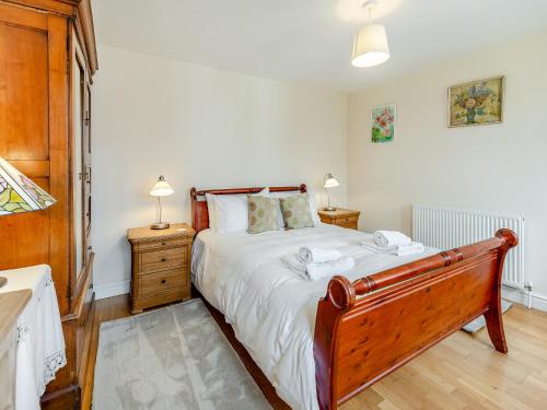 a bedroom with a large bed and two night stands at The Coach House in Aldington