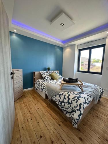 una camera con letto e parete blu di Agréable Maison avec jacuzzi a Maisdon-sur-Sèvre