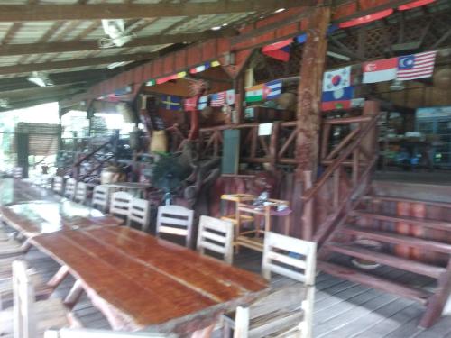 a dining room with a wooden table and chairs at Sainamhai Resort in Ban Namsanam