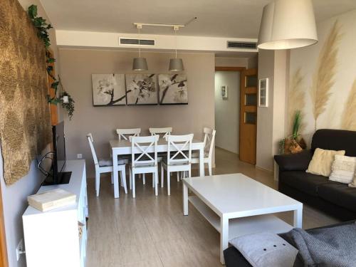 een woonkamer met een tafel en een witte tafel en stoelen bij Peñiscola centro capri in Peñíscola