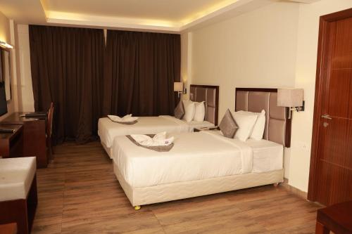 a hotel room with two beds and a desk at Paravoor Galaxy Hotel in Cherai Beach