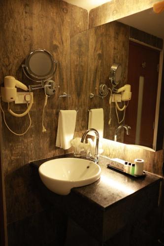 a bathroom with a sink and a mirror at Paravoor Galaxy Hotel in Cherai Beach