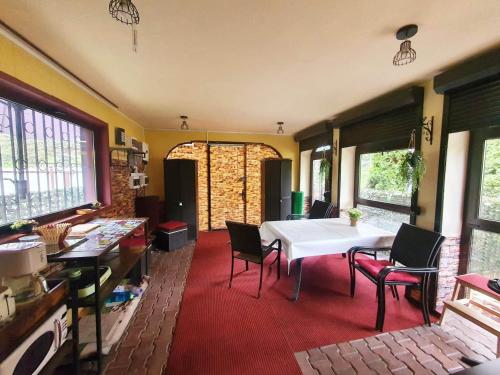 une salle à manger avec une table et des chaises blanches dans l'établissement Magic Home, à Slănic