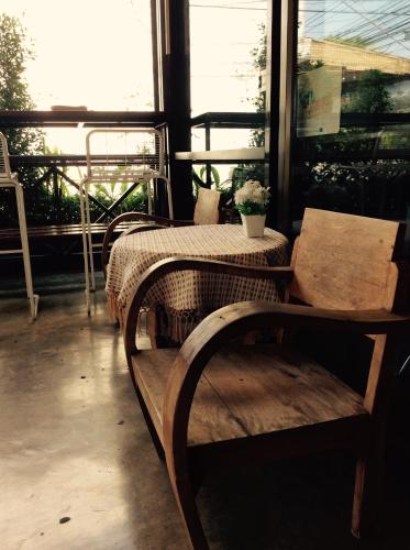 a porch with a table and a table and chairs at EZ House in Sukhothai