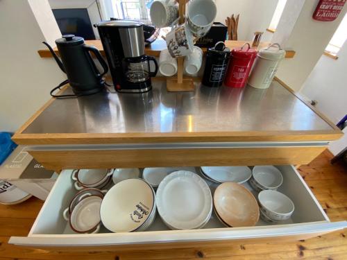 a shelf with plates and cups in a kitchen at 貸別荘Casa de Campo 2SLDK别墅 駐車場 芝生東屋付き BBQ 大室山と海遠望伊豆高原5分 in Ito