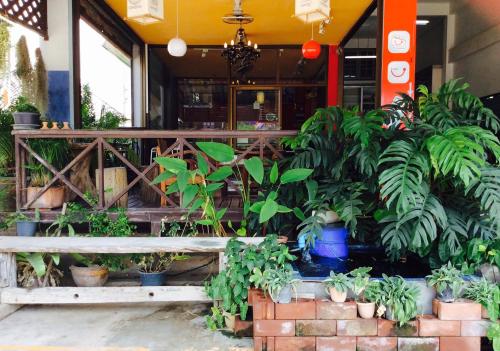 a bench in front of a building with plants at EZ House in Sukhothai