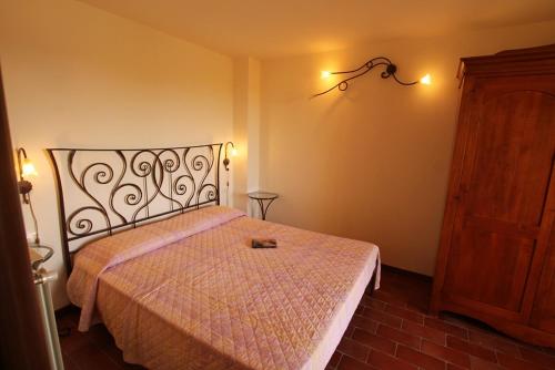 1 dormitorio con 1 cama con colcha rosa en Casa Sara con Wifi e piscina comune, a soli 2 km dal mare en Cecina