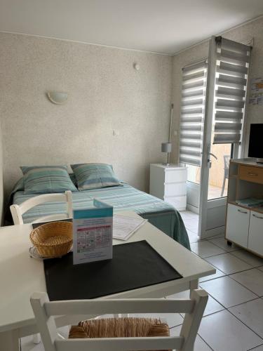 a bedroom with a bed and a table with a sign on it at Hôtel Résidence Les Flots in Saint-Palais-sur-Mer