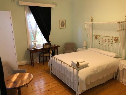 a bedroom with a bed and a table and a window at Lorelei Bed & Breakfast in Portland