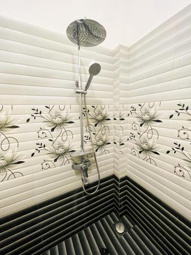 a bathroom with a shower with flowers on the wall at Sigiriya Green Garden Home in Sigiriya