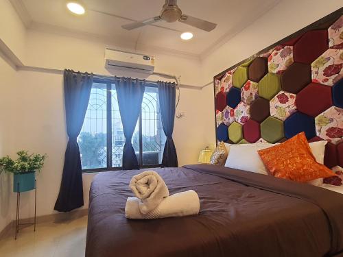 a bedroom with a bed with a stuffed animal on it at OSI Apartments Perry Cross Bandra West in Mumbai