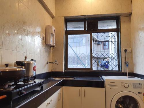 a kitchen with a stove and a sink and a window at OSI Apartments Perry Cross Bandra West in Mumbai