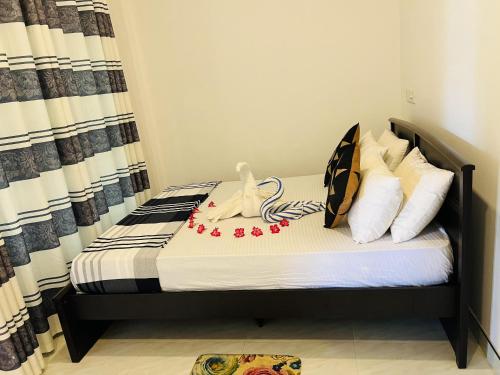 a small bedroom with a bed with pillows at Sigiriya Green Garden Home in Sigiriya