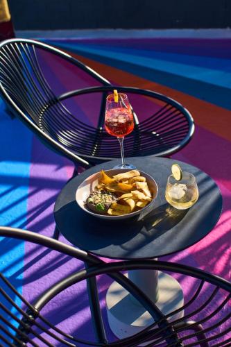 a plate of food and a glass of wine on a table at The Ven at Embassy Row, Washington, D.C., a Tribute Portfolio Hotel in Washington
