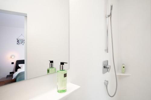 bagno bianco con specchio e doccia di B&B Lucy in the Sky ad Anversa