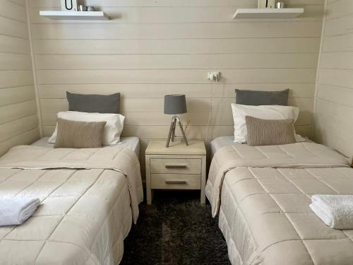 2 camas individuales en una habitación con mesita de noche en JC COTTAGE, en Harden