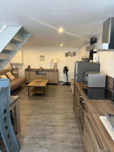 a kitchen and living room with a couch and a table at maison proche Disneyland , parc des Félins et Coulommiers in Saint-Augustin