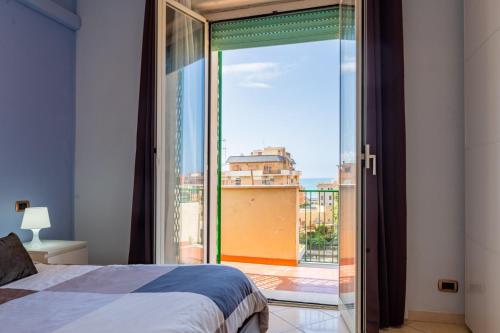 リド・ディ・オスティアにあるAttico Triremiのベッドルーム1室(ベッド1台付)、スライド式ガラスドアが備わります。