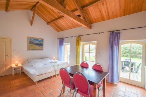 a bedroom with a bed and a table and chairs at Domaine d'Essendiéras in Saint-Médard-dʼExcideuil